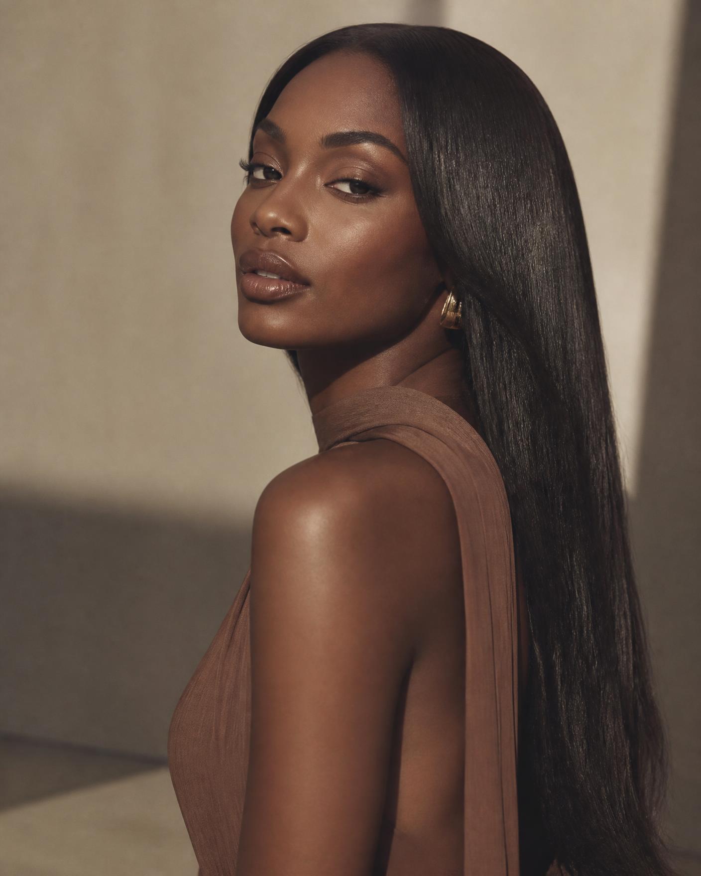 Model wearing a sleek, glossy Mirah.x.hair straight wig in warm studio light